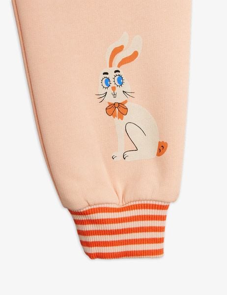 Pink sweatpants featuring a white Rabbit print and orange and white striped ribbed cuffs.