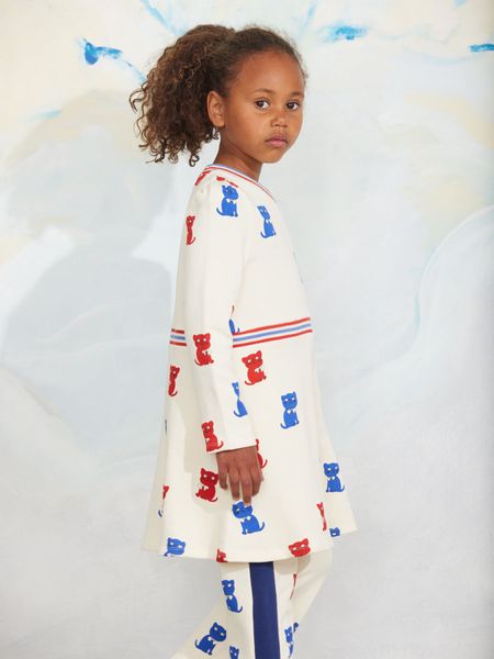 Off-white sweatdress featuring a Kittens print, V-neck, and striped waistband, worn by a child.