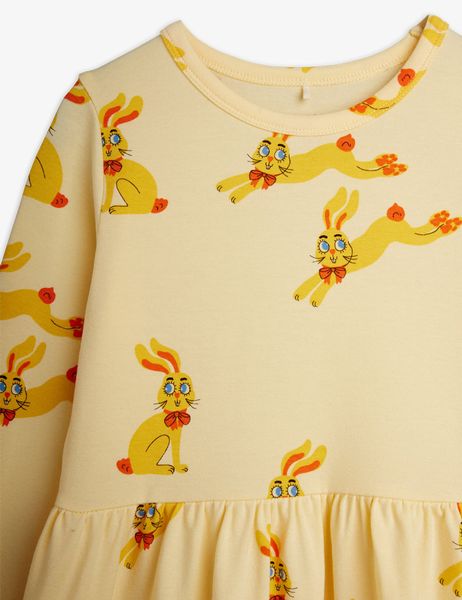 Close-up of a yellow long-sleeved dress featuring a Rabbits print and a gathered waist.