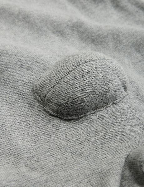 Close-up of a grey melange fine knit fabric with a 3D padded detail.
