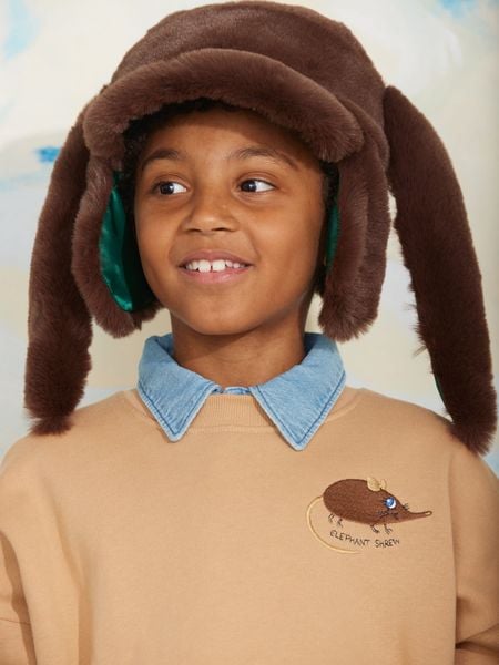 Brown faux fur rabbit ear cap worn by a child.