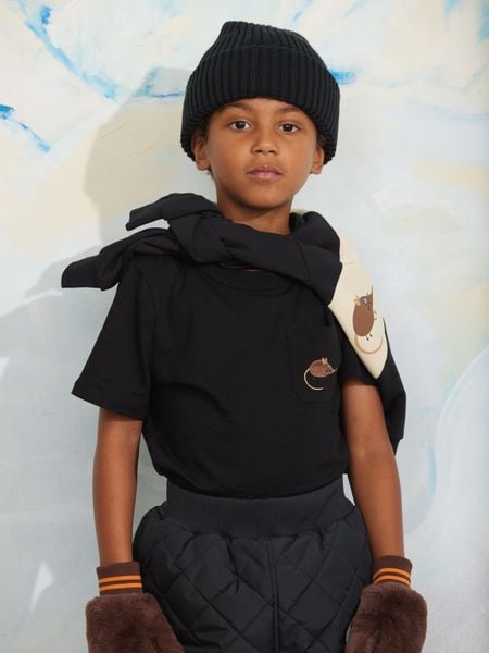 Black short-sleeved t-shirt with a chest pocket and elephant shrew embroidery, worn by a child in a beanie.