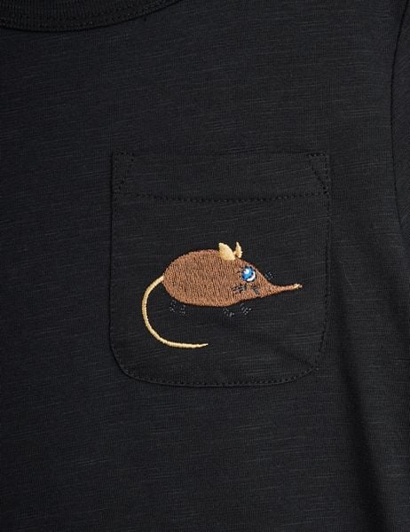 Close-up of a black T-shirt chest pocket featuring a brown embroidered Elephant Shrew motif.