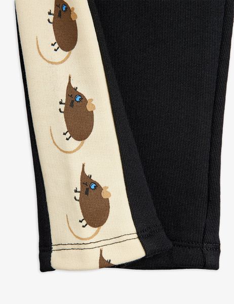 Close-up of black sweatpants featuring a cream side panel with brown Elephant shrew motifs.