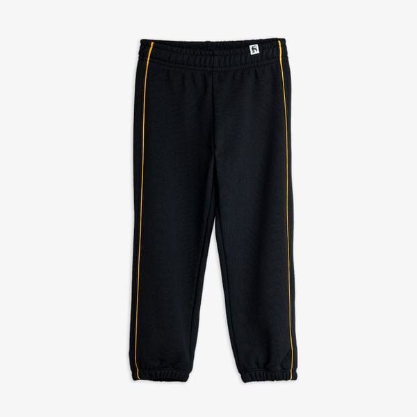 Black sweatpants featuring yellow piping details along the legs, shown from the front.