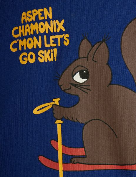 Close-up of a blue t-shirt featuring a Skiing squirrel print and yellow text.