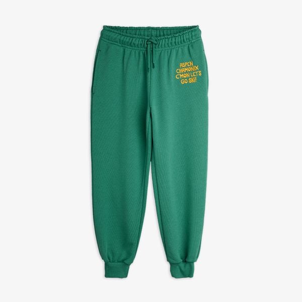 Green organic cotton sweatpants featuring an embroidered Aspen Chamonix text, elastic drawstring waist, and ribbed cuffs.
