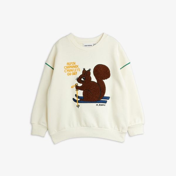 Off-white crew neck sweatshirt featuring a brown Skiing Squirrel chenille patch and green piping details.
