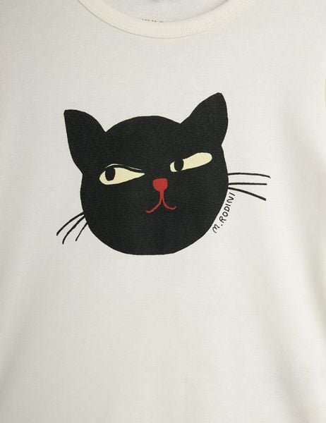 Close-up of a black cat print with a red nose on an off-white fabric.