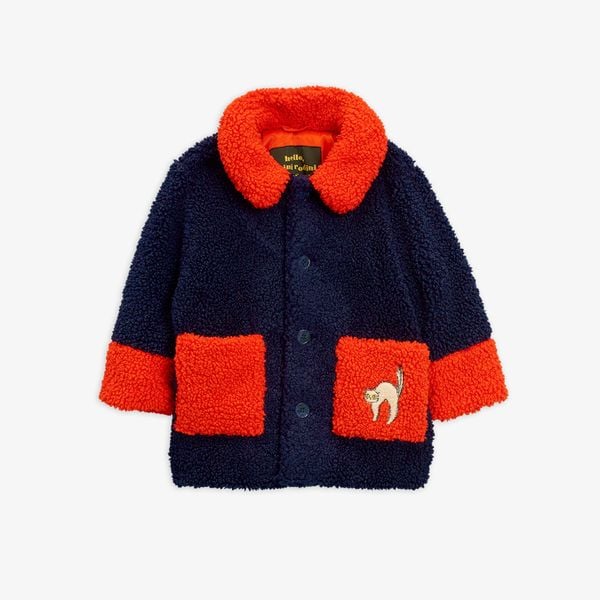 Blue faux fur jacket with contrasting red collar, cuffs, and front pockets, featuring an embroidered cat on the pocket.