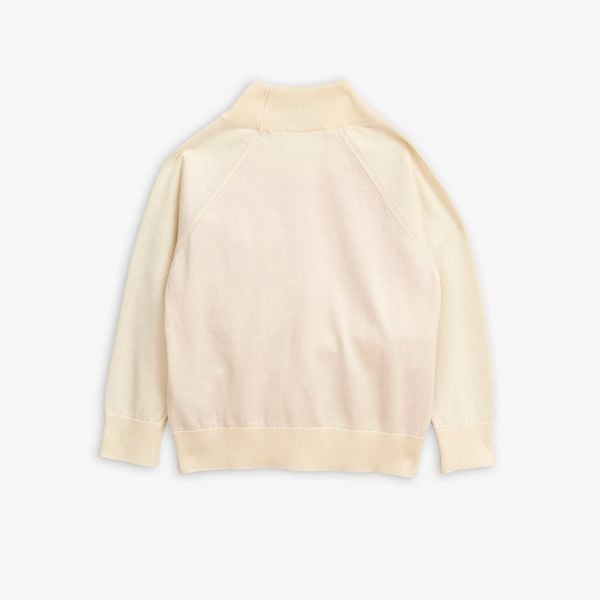 Beige knitted sweater featuring a ribbed high neckline and long sleeves, shown from the back.
