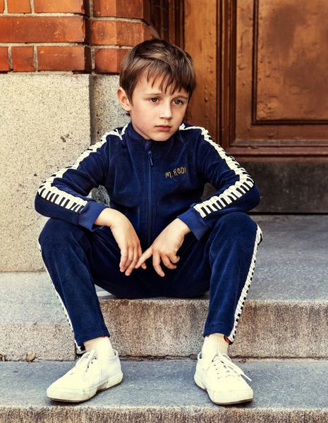 Navy terry jacket featuring piano key tape along the sleeves and a front zip.
